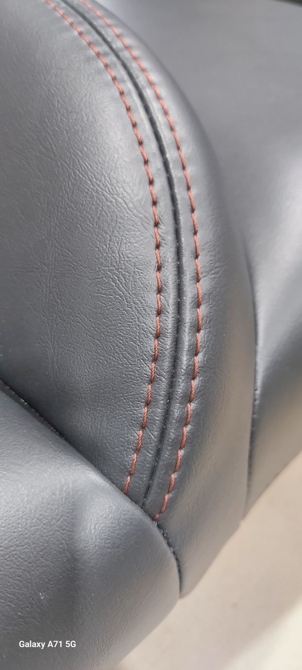 Detailed custom leather upholstery close-up showing intricate stitching patterns and premium finish