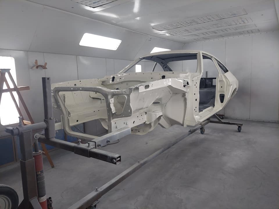 Master craftsman working on vintage car bodywork restoration in a professional workshop